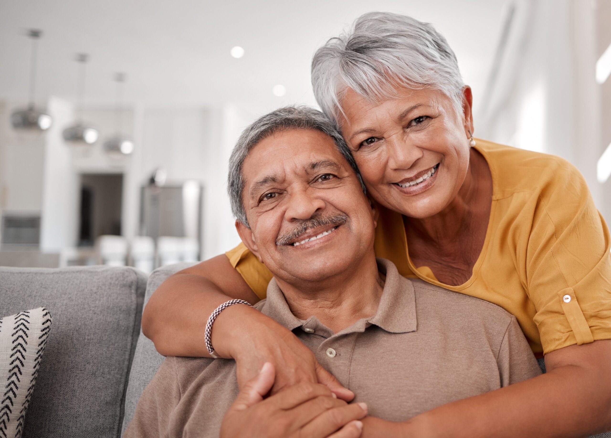 Grandparents smile on sofa